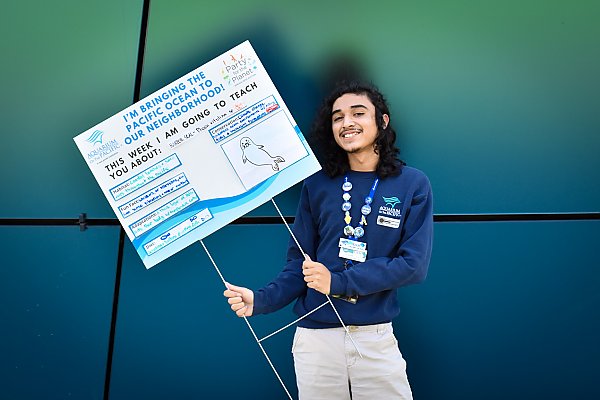 Person holding a home-made Ocean Neighbors sign about seals